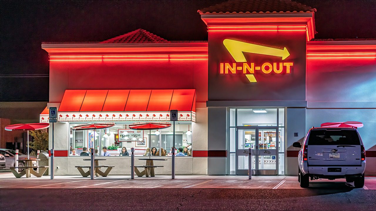 In-N-Out Burger restaurant lit up with neon lights at night.